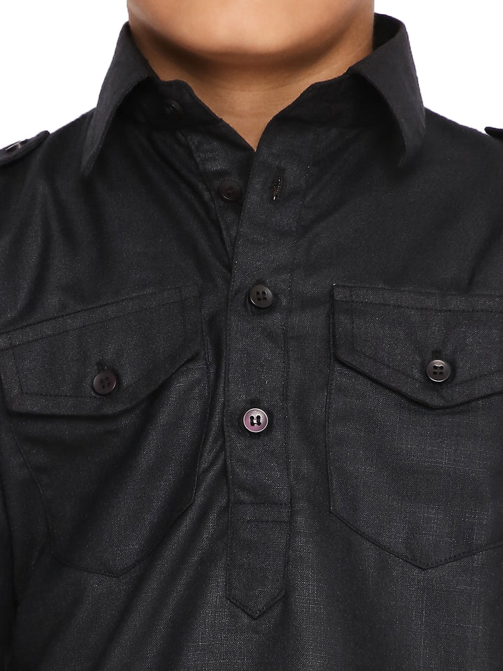 Close-up of boys black kurta showing button placket and dual chest pockets, highlighting fine detailing and craftsmanship.