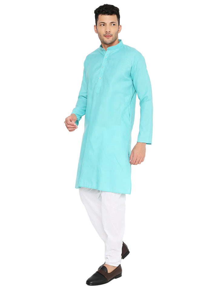 Side pose of man wearing turquoise cotton kurta with white pants, highlighting the kurta's relaxed fit and elegant silhouette.