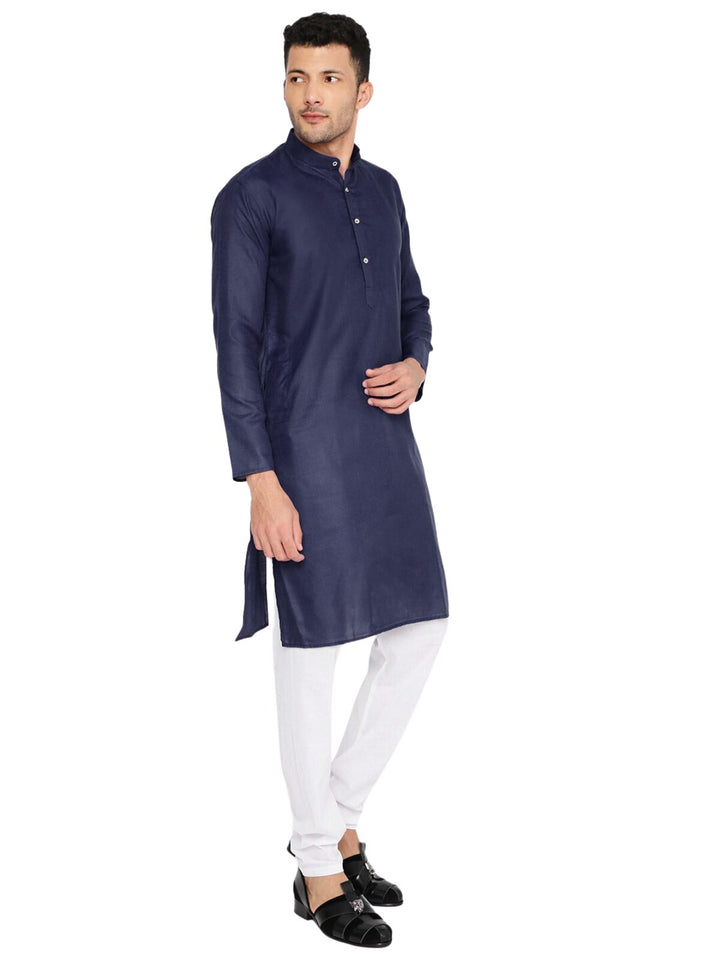 Side pose of man wearing dark blue kurta with white pajama, highlighting the kurta's tailored fit and elegant silhouette.