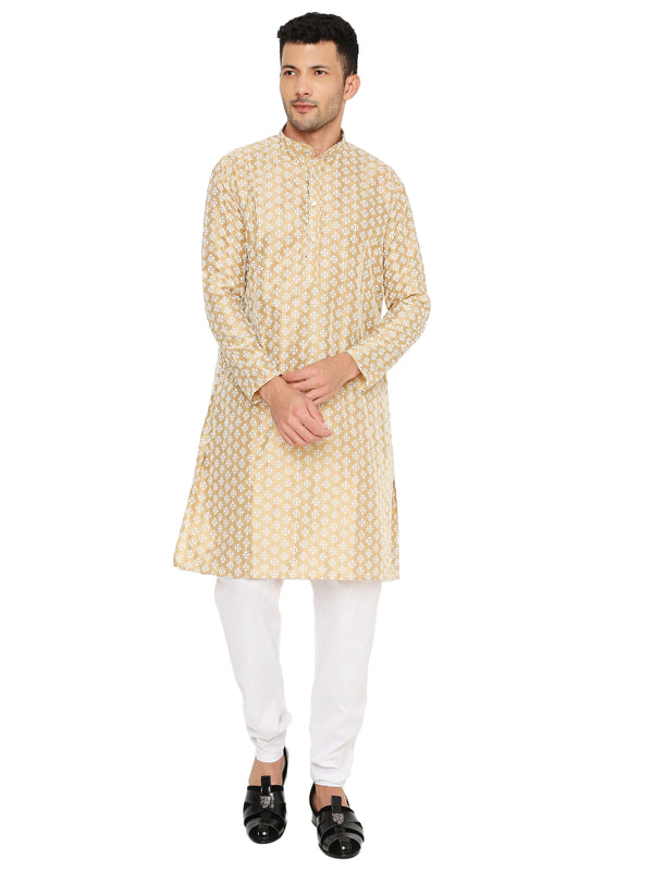 Golden Banarasi Silk Kurta for men featuring traditional floral weave, ideal for weddings and festivals. Styled with white churidar and black footwear.
