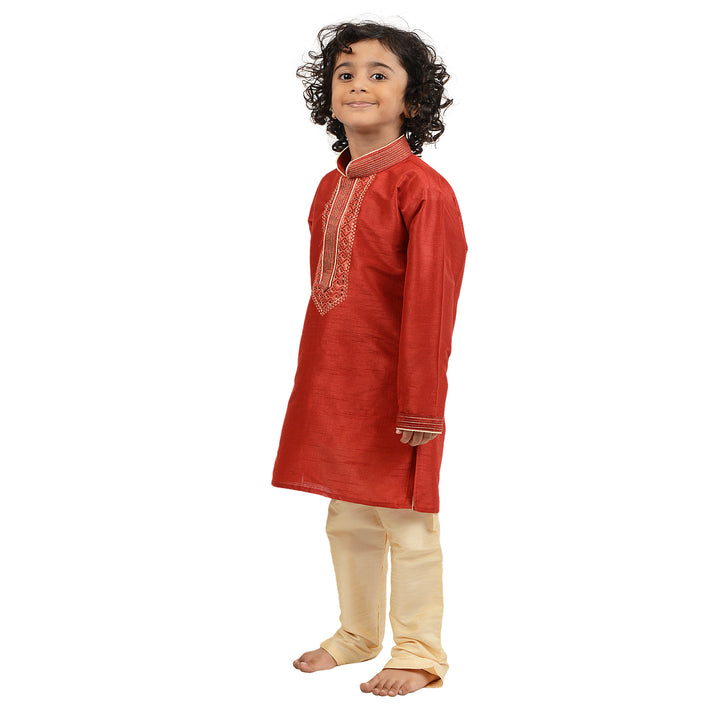 Side view of Kids Gold Kurta Set featuring red art silk kurta with intricate gold embroidery and cream churidar, ideal for ceremonial wear.
