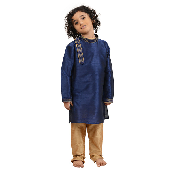 Blue Kids Kurta Set - Art Silk Side Button features a boy wearing a navy blue kurta with beige churidar, ideal for festive occasions.