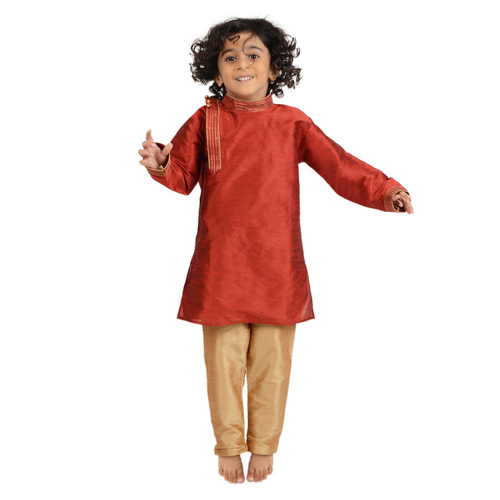Boy jumping in Red Art Silk Kids Kurta Set - Maharaja, showcasing playful comfort and vibrant style for traditional celebrations.