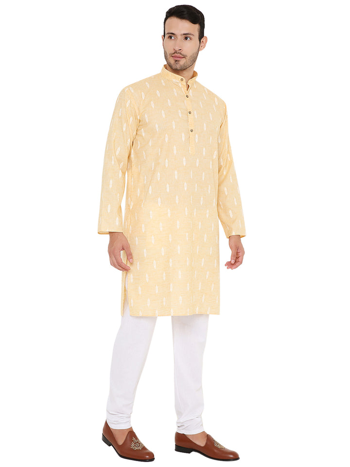 Angled front view of yellow linen kurta with white motifs, styled with white bottoms and brown loafers for a festive look.