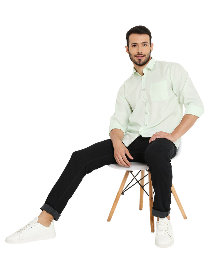 Model wearing Slim Fit Pastel Green Shirt paired with black jeans and white sneakers, showcasing a relaxed yet stylish outfit.
