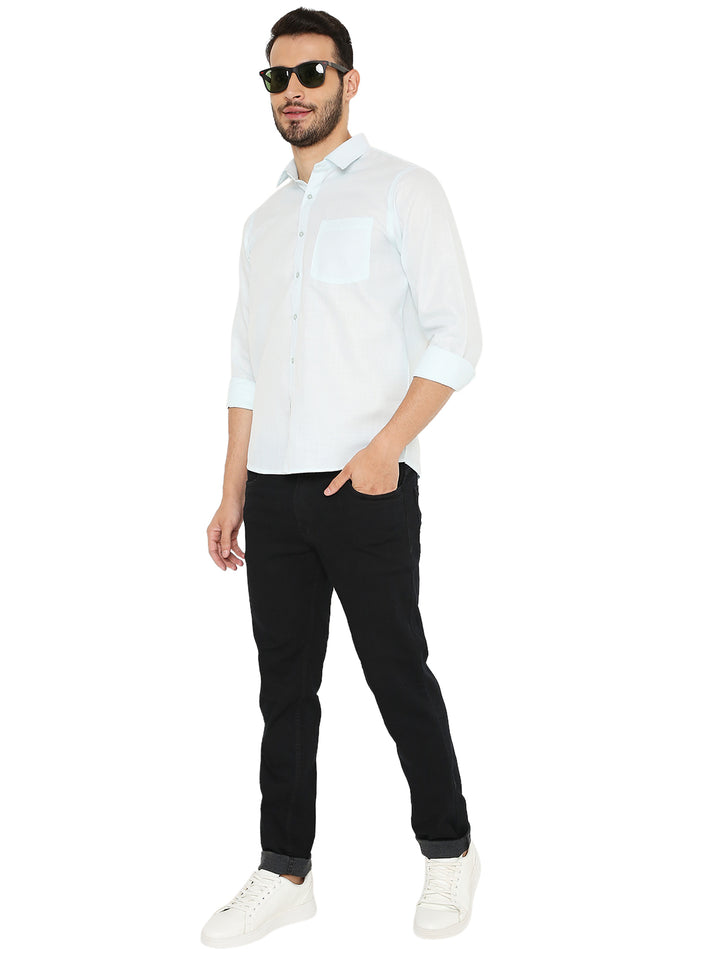 Full-body view of man wearing pastel blue Slim Fit Shirt with black jeans and white sneakers, styled for casual fashion.