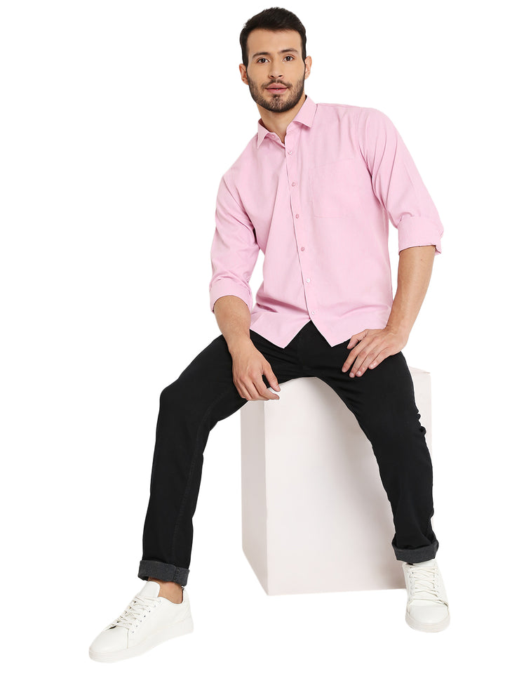 Model wearing Maharaja Slim Fit Pink Shirt with rolled sleeves, paired with black jeans and white sneakers for a smart casual outfit.